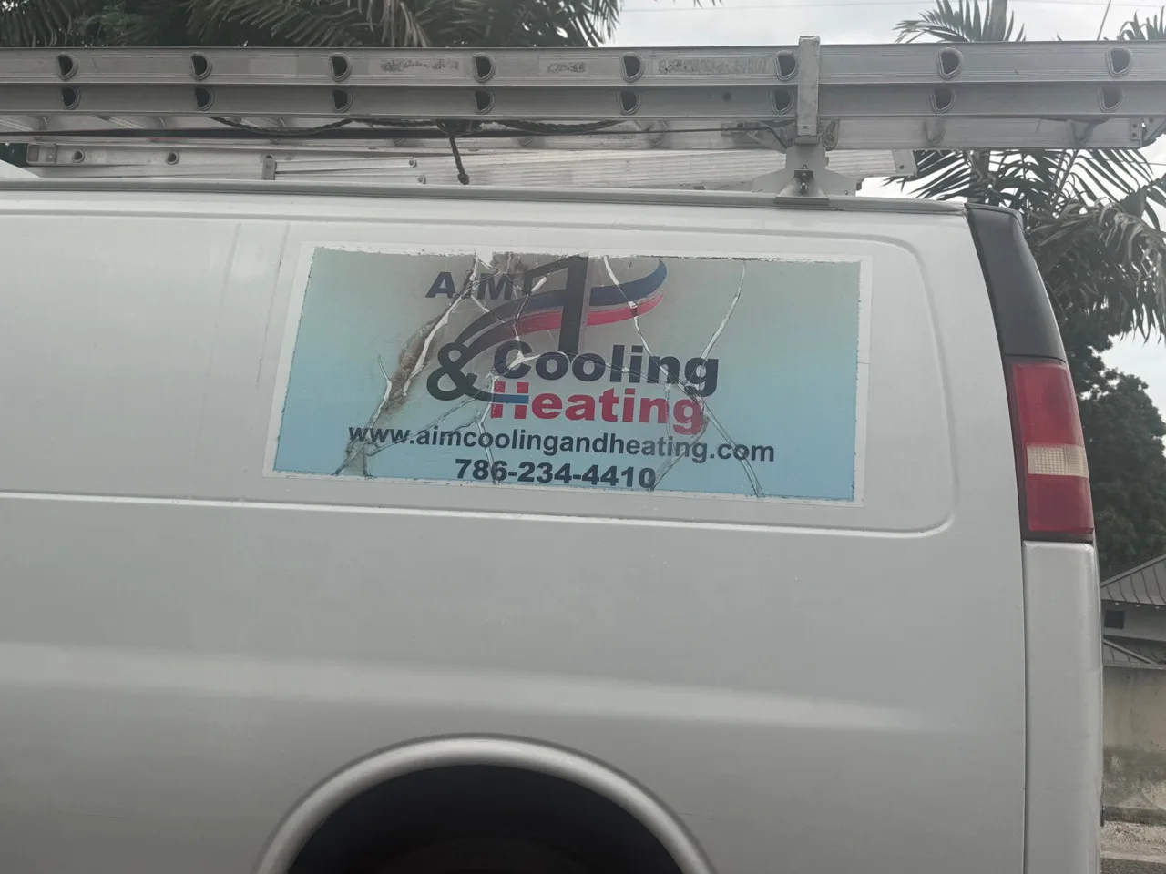 AIM Cooling and Heating work vehicle displaying business contact information