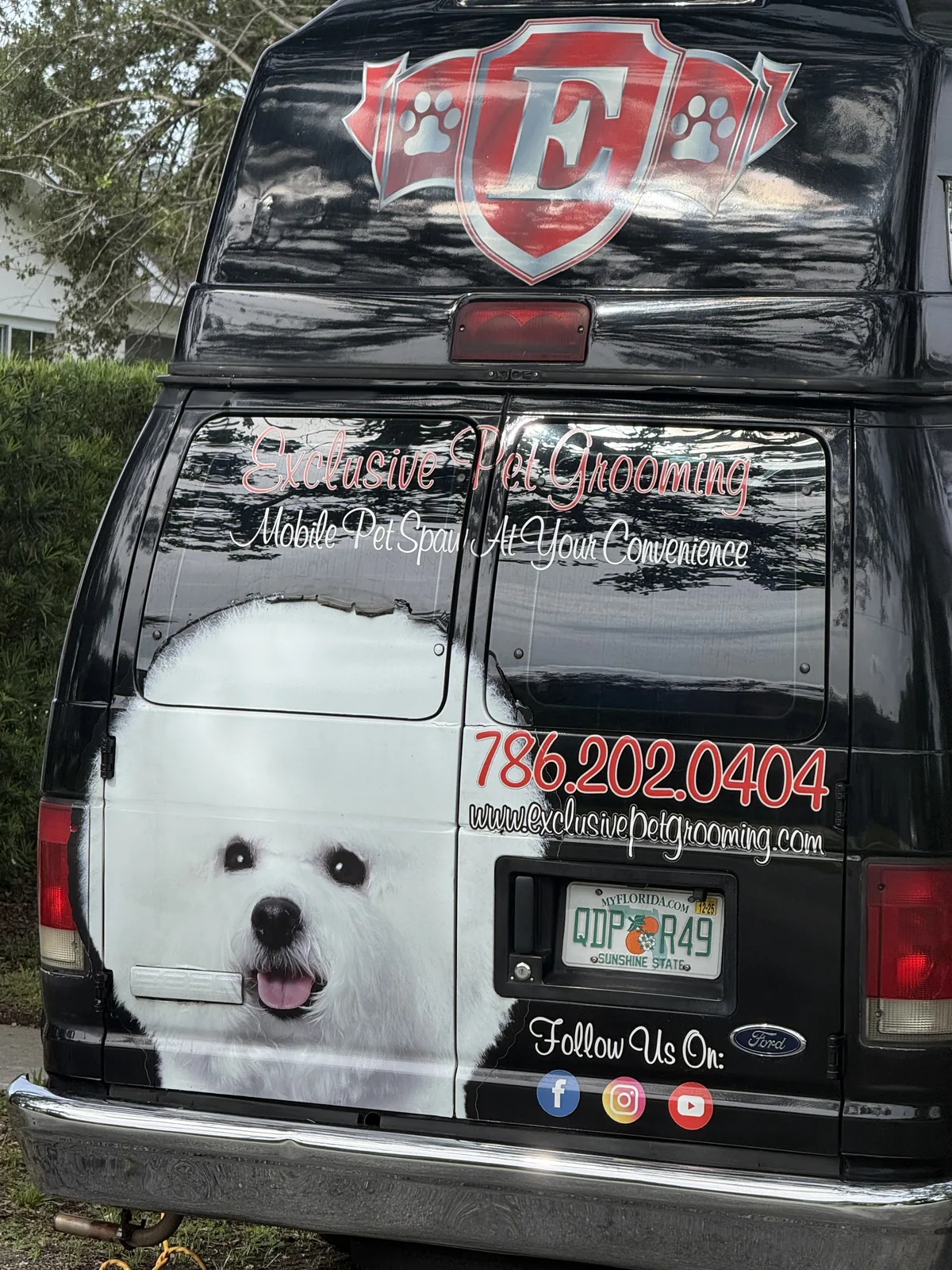 Black Exclusive Pet Grooming mobile spa van with phone number and website