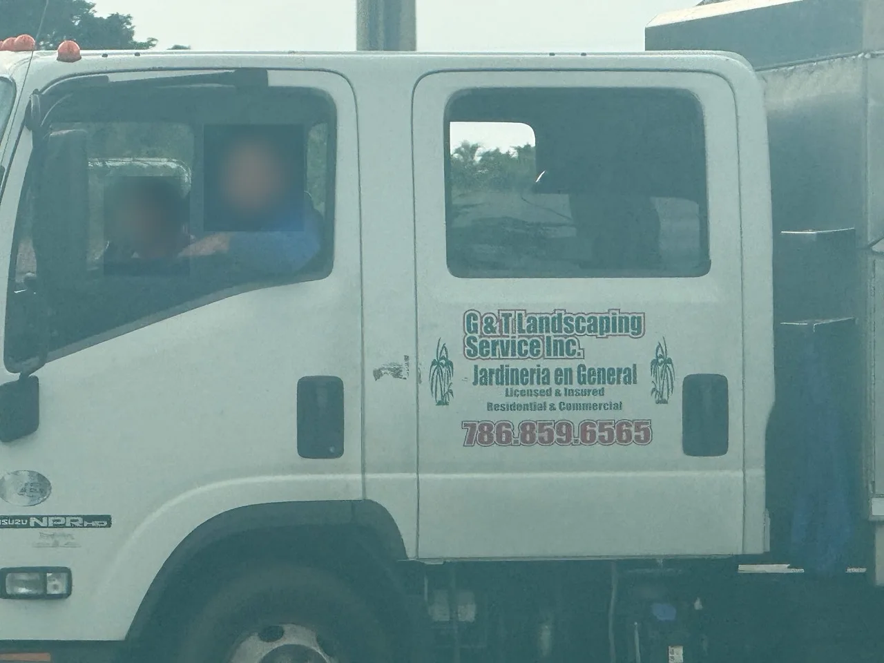 G&T Landscaping Service Inc. work vehicle displaying business contact information; visible faces blurred for privacy