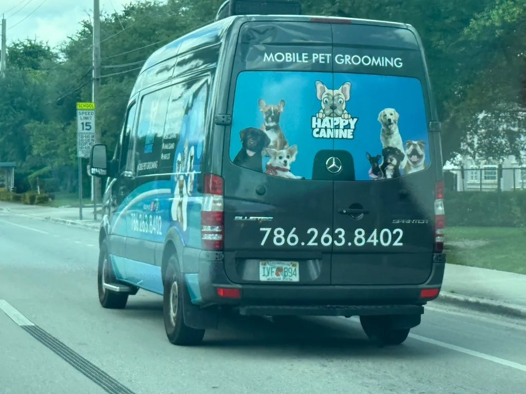 Happy Canine work vehicle showing business branding and phone