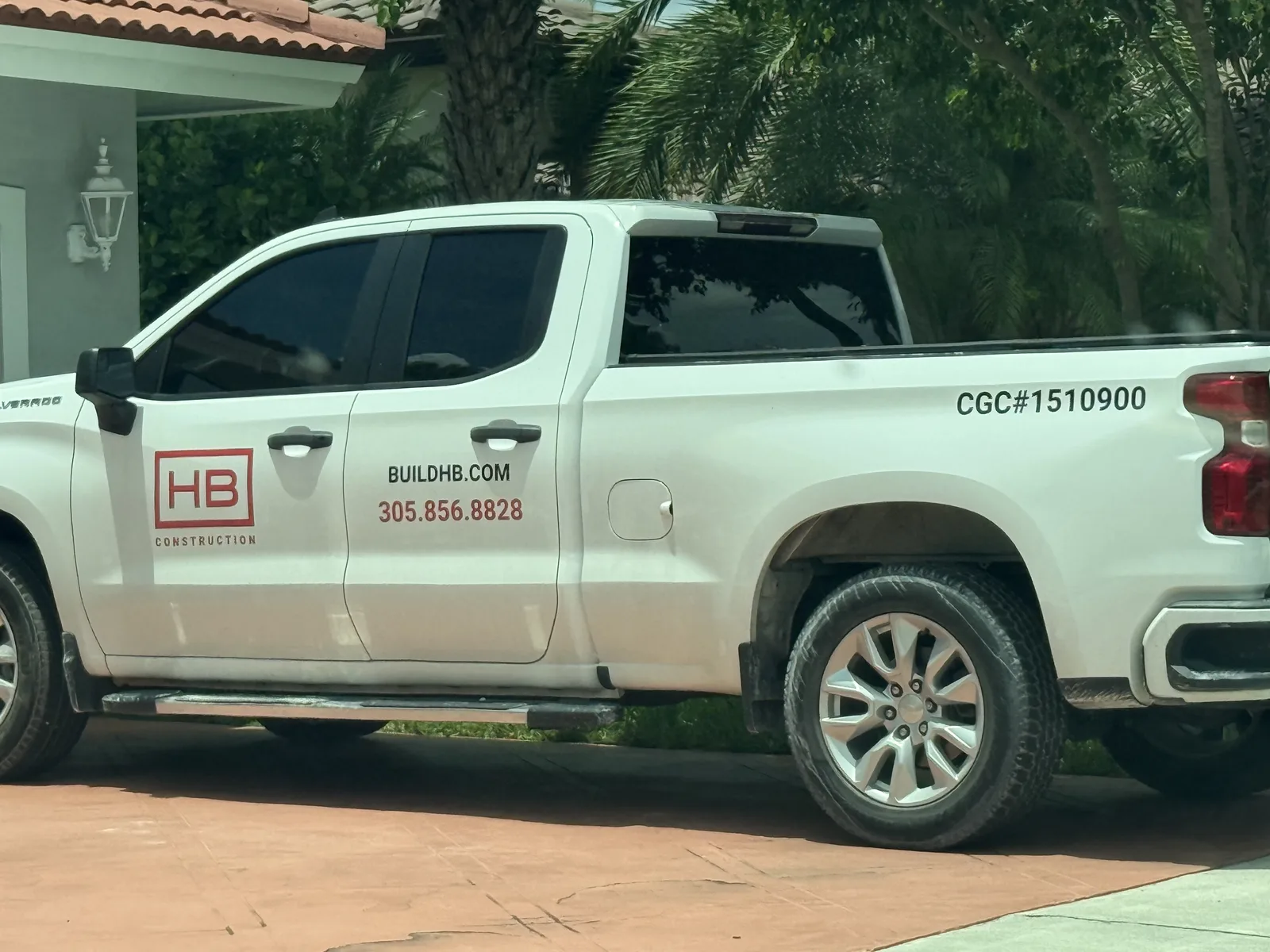 White HB Construction pickup truck with website, phone number, and contractor license