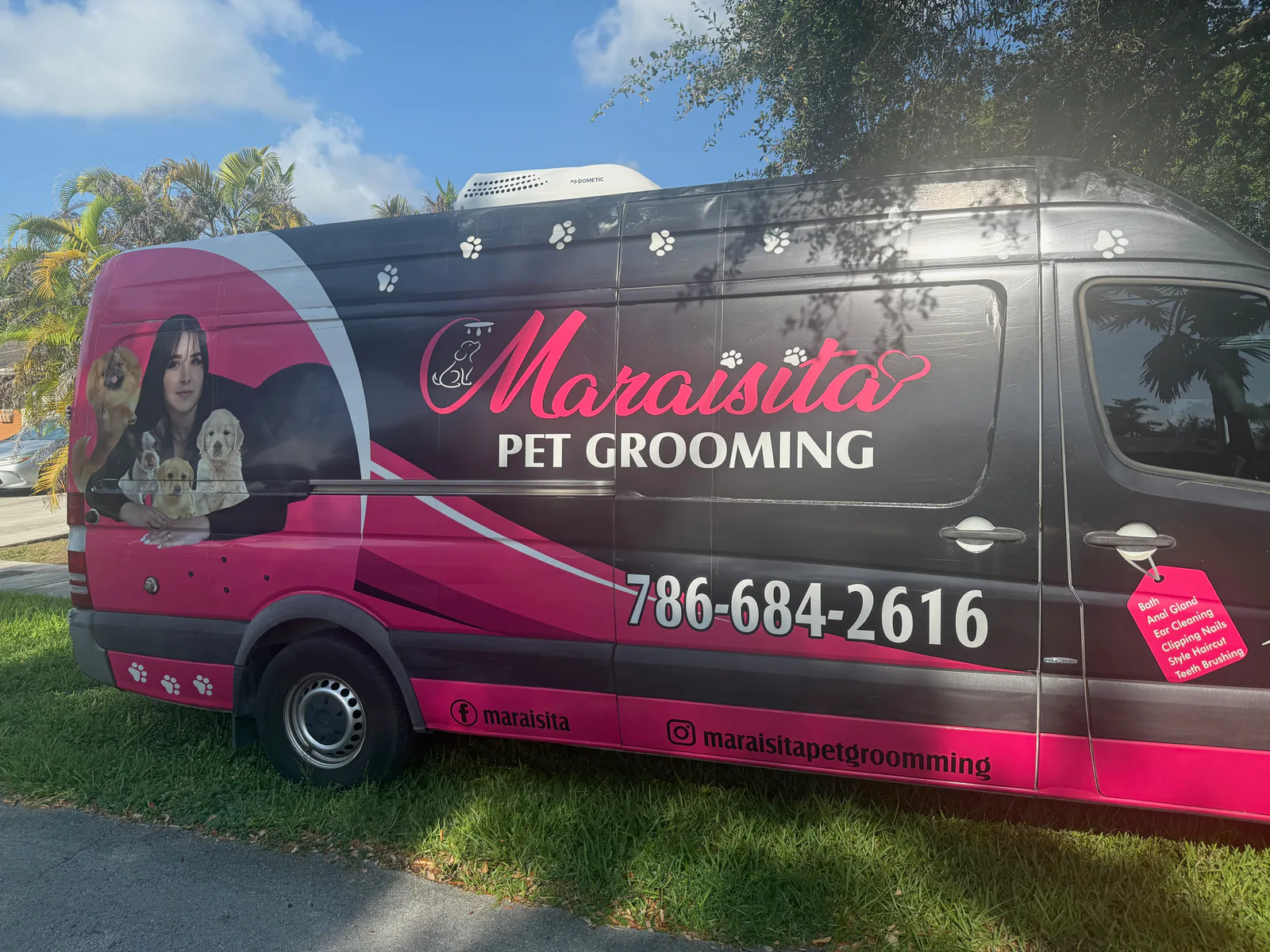 Pink and black Maraisita Pet Grooming mobile grooming van displaying phone number 786-684-2616 and a list of grooming services