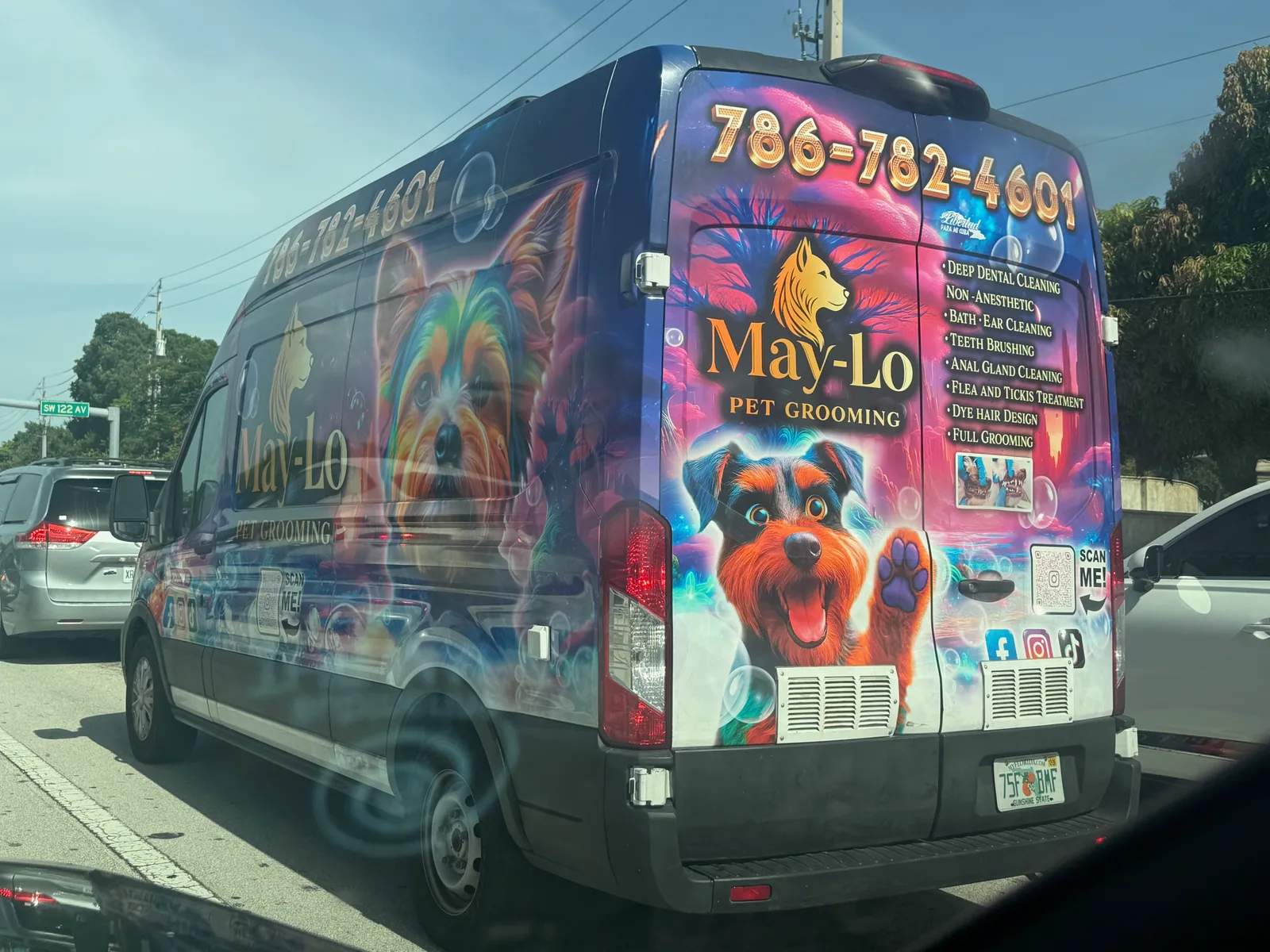 Colorfully wrapped May-Lo Pet Grooming van displaying phone number 786-782-4601 and grooming services