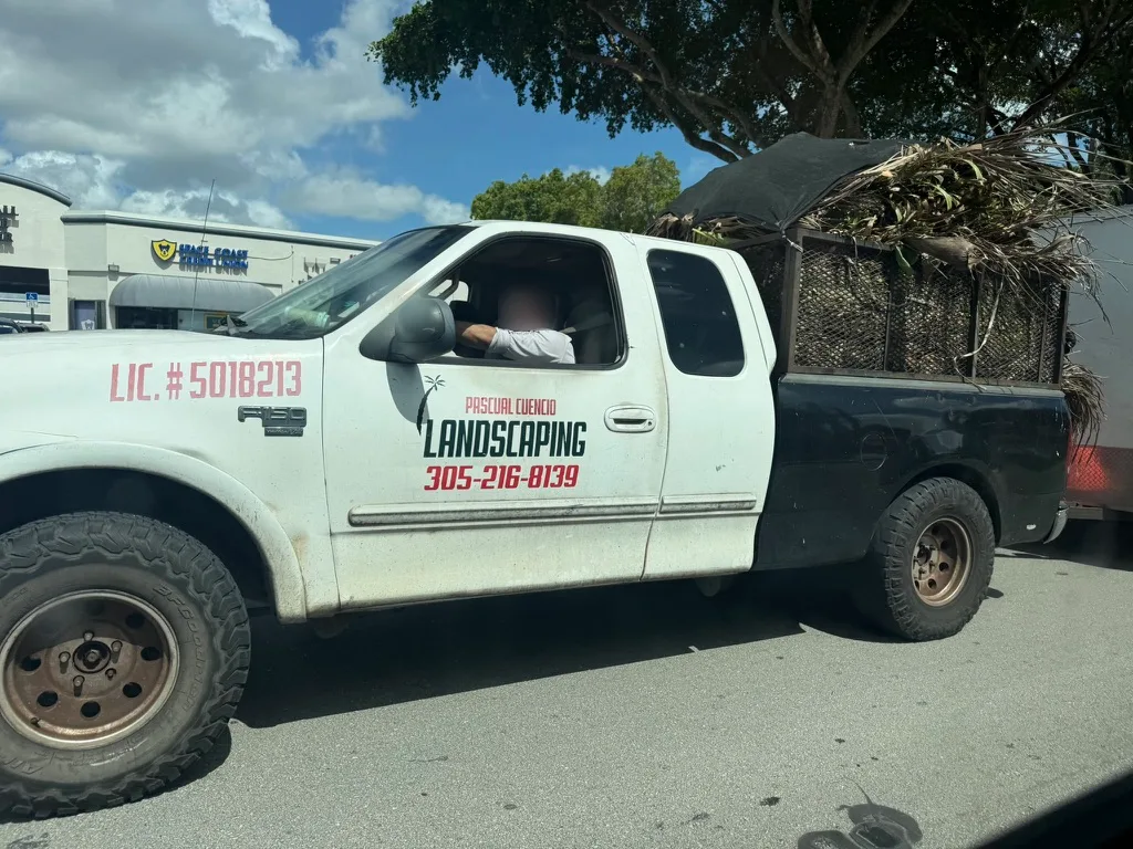 Pascual Landscaping work vehicle showing business branding and phone; driver's face blurred for privacy