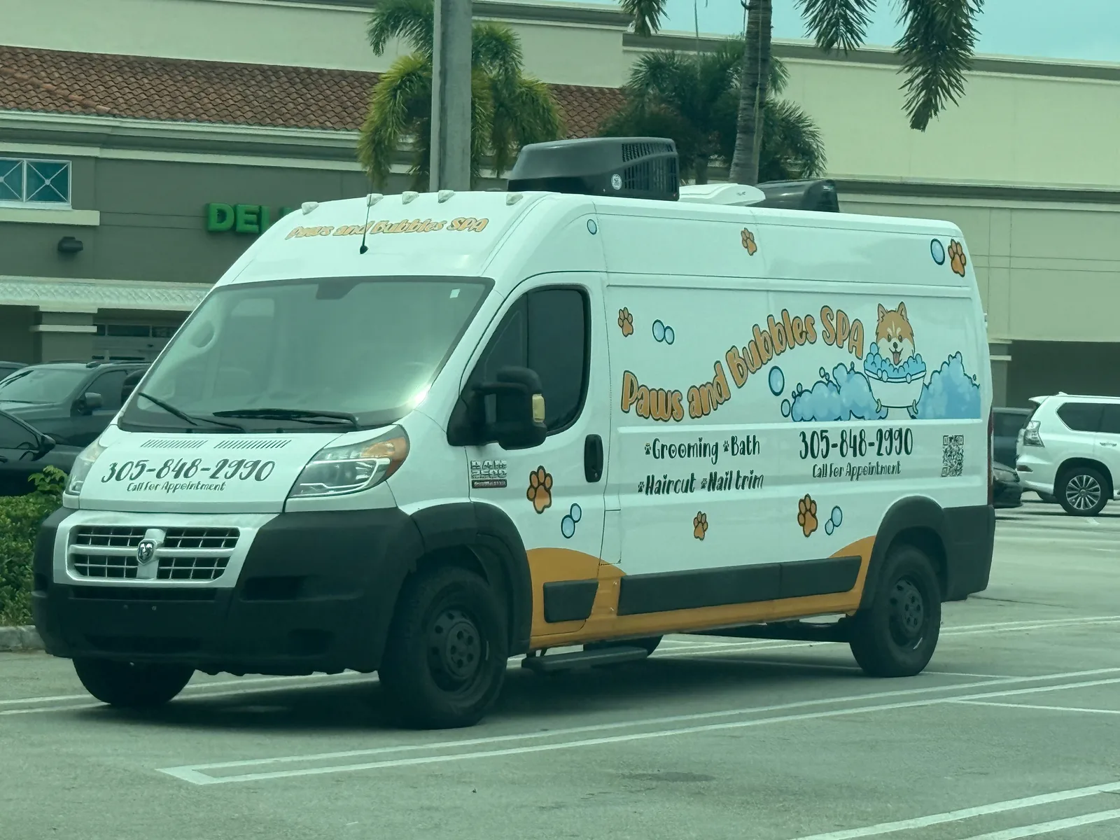 Paws and Bubbles SPA work vehicle displaying its name and phone number