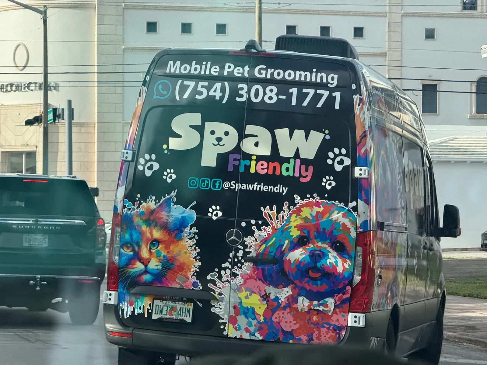 Colorful Spaw Friendly mobile pet-grooming van displaying WhatsApp number 754-308-1771 and social handle Spawfriendly