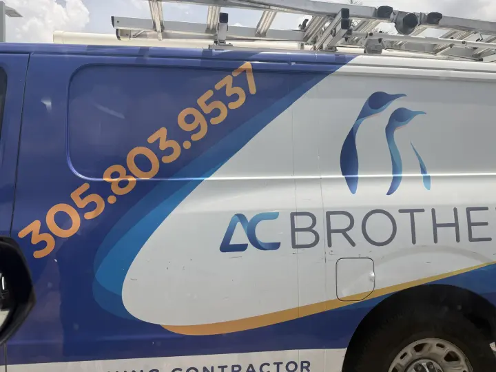 Blue and white AC Brothers HVAC service van with the Miami phone number in large lettering