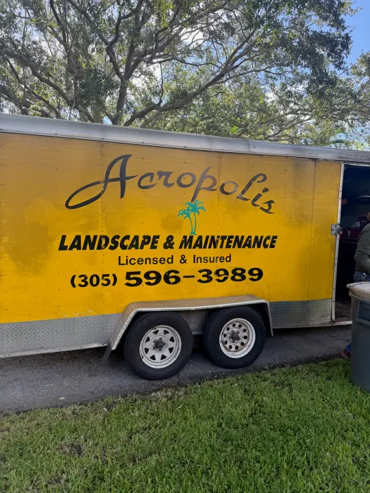 Yellow Acropolis Landscape and Maintenance equipment trailer displaying phone number 305-596-3989