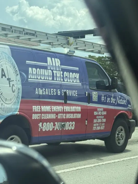 Blue and red Air Around the Clock service van photographed on a South Florida road
