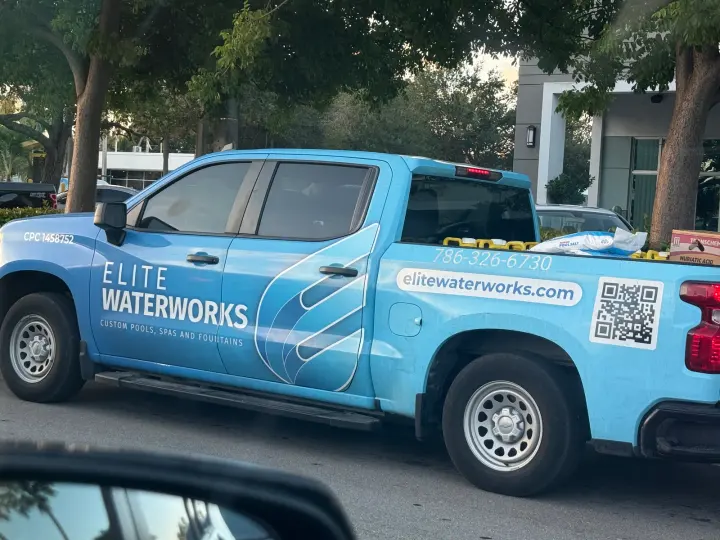 Elite Waterworks Inc. work vehicle displaying its business signage and contact information