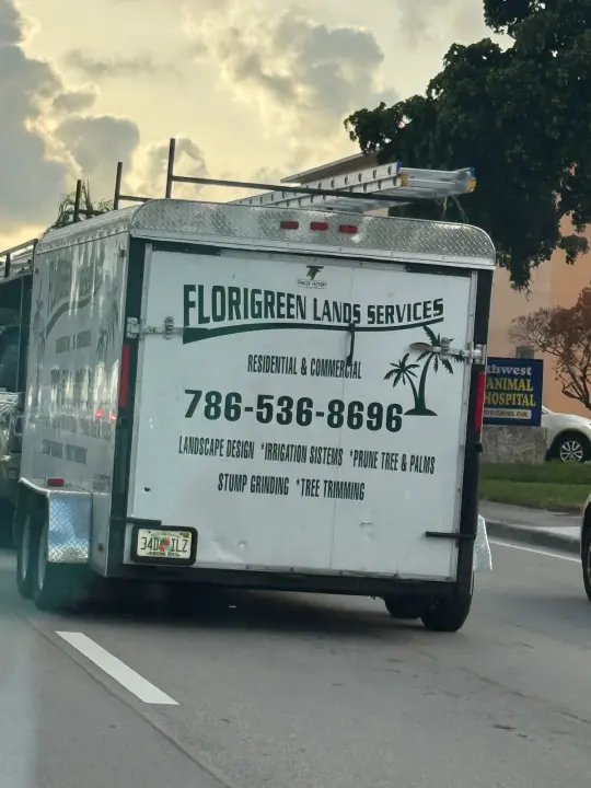 Florigreen Lands Services trailer displaying phone number 786-536-8696 and landscaping services