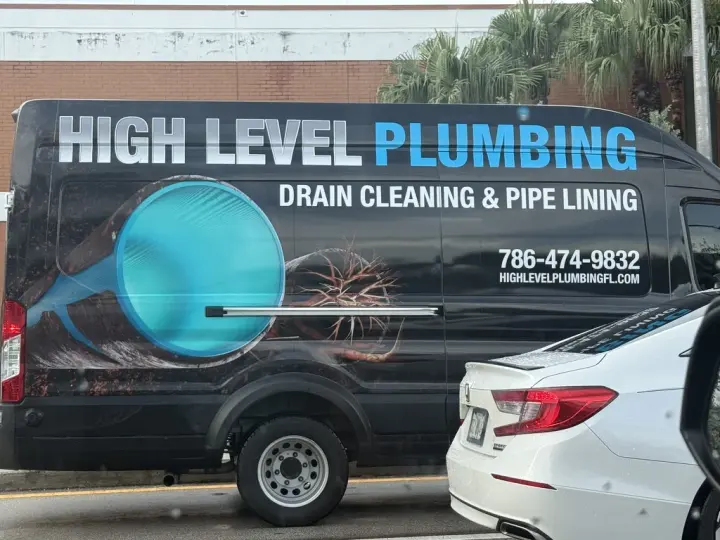Black High Level Plumbing van advertising drain cleaning, pipe lining, phone number, and website