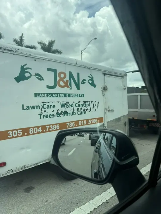 White J and N Landscaping and Nursery trailer advertising lawn, weed, tree, and shrub care