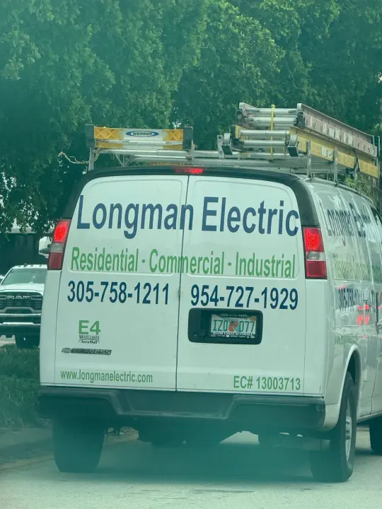 Longman Electric work vehicle displaying its business name and contact information