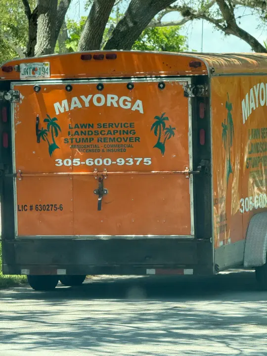 Mayorga Lawn Service work vehicle displaying its business signage and contact information