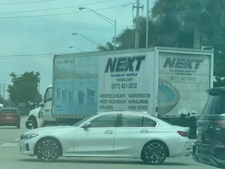 Next Plumbing Supply delivery truck displaying nextps.com, phone number 877-421-3212, and Florida service locations including Doral and Miami