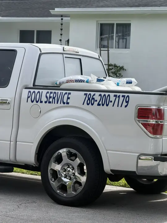 White pickup truck marked Pool Service with the phone number 786-200-7179
