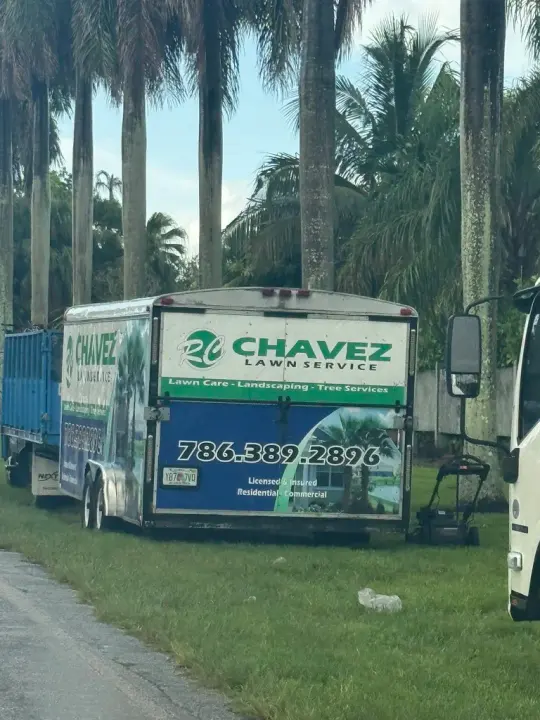 RC Chavez Lawn Service trailer advertising lawn care, landscaping, tree services, and phone number