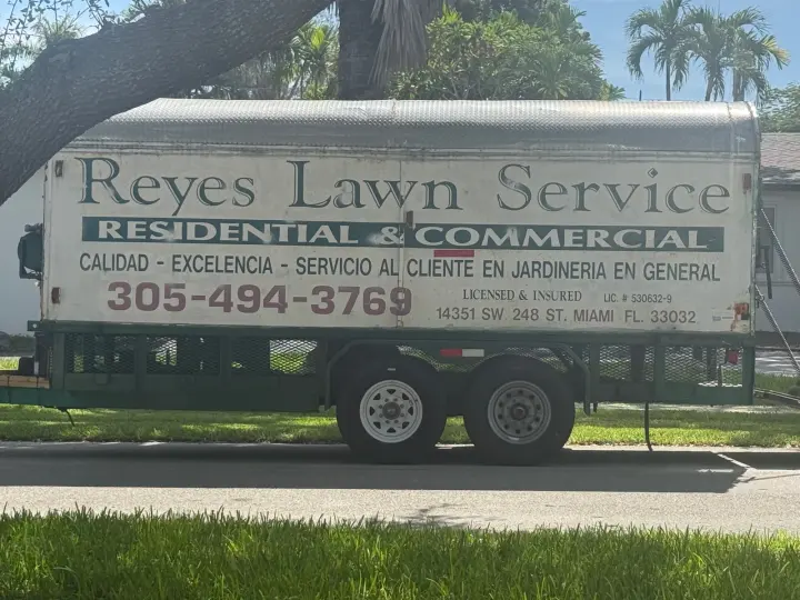 Reyes Lawn Service work vehicle displaying its business signage and contact information