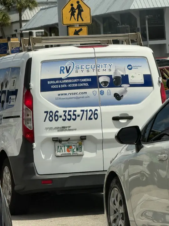 RV Security Systems work van displaying phone, email, website, and security-system services
