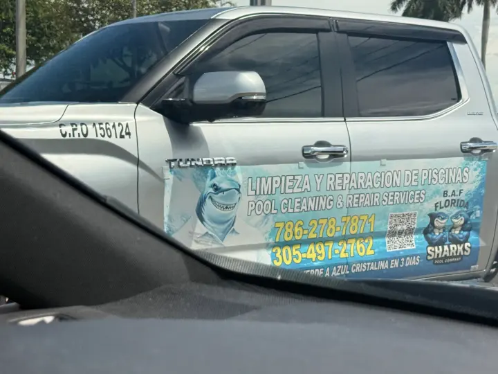 Sharks Pool Company work vehicle displaying its business signage and contact information