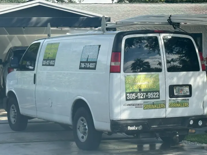 White SS Well Drilling & Sprinklers work van displaying 305-927-9522 and a sprinkler-repair sign with 786-718-0337