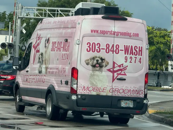 Pink Superstar Grooming mobile grooming van displaying superstargrooming.com and 303-848-WASH