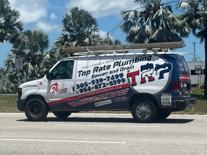 Top Rate Plumbing Sewer and Drain service van displaying two phone numbers and 24-hour service branding