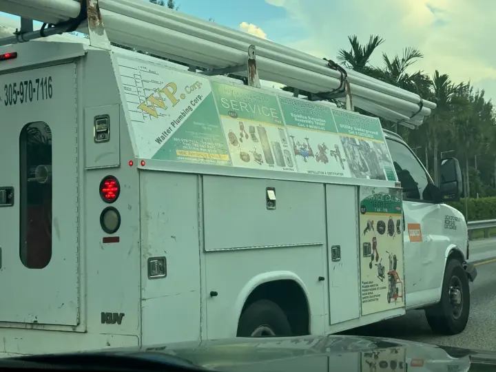 Walter Plumbing Corp service truck displaying plumbing equipment, service information, and phone number 305-970-7116