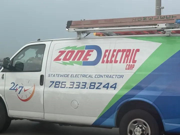 Zone D Electric Corp work vehicle displaying its business signage and contact information