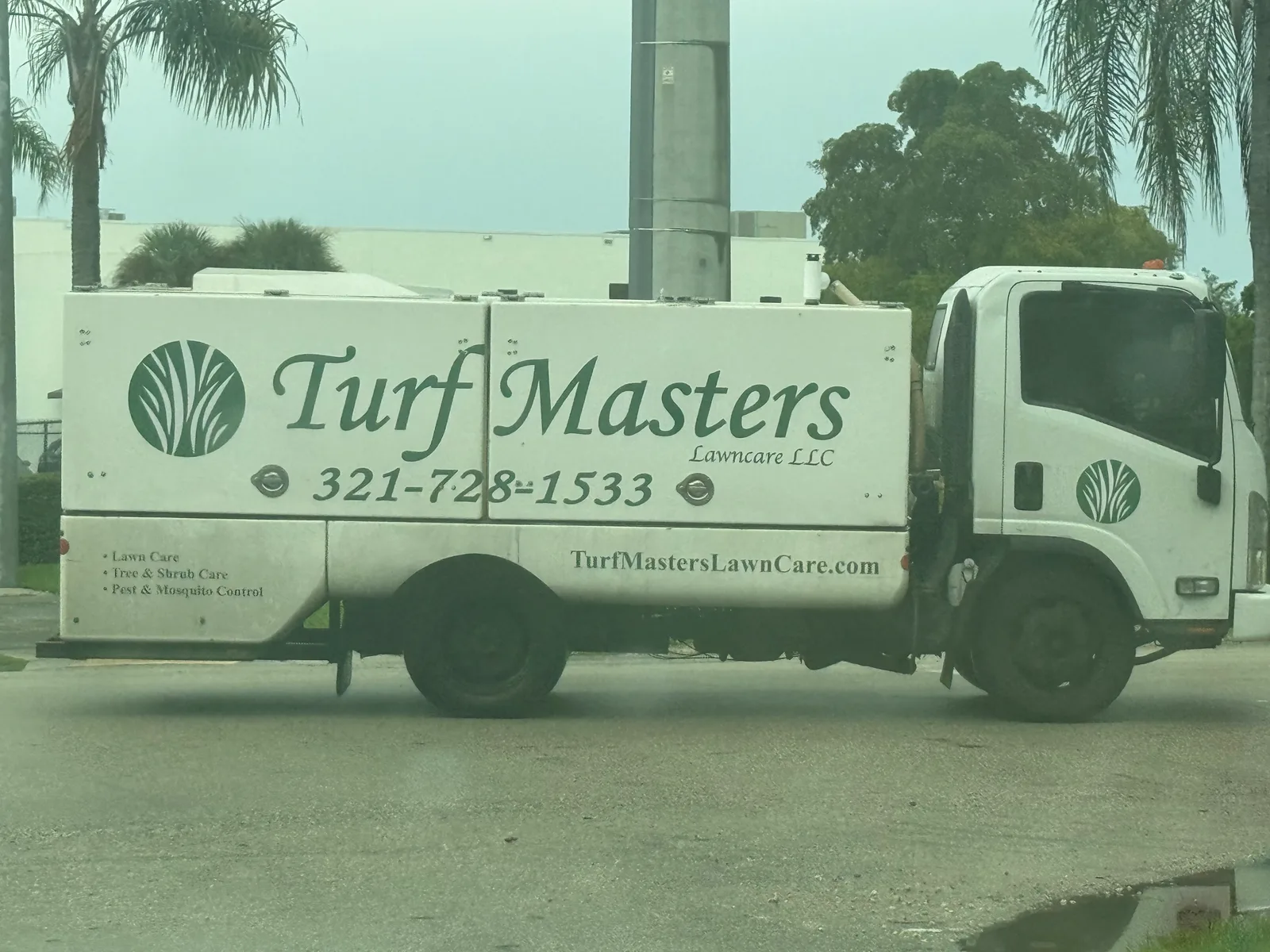 Turf Masters Lawn Care work vehicle displaying its business name and contact information